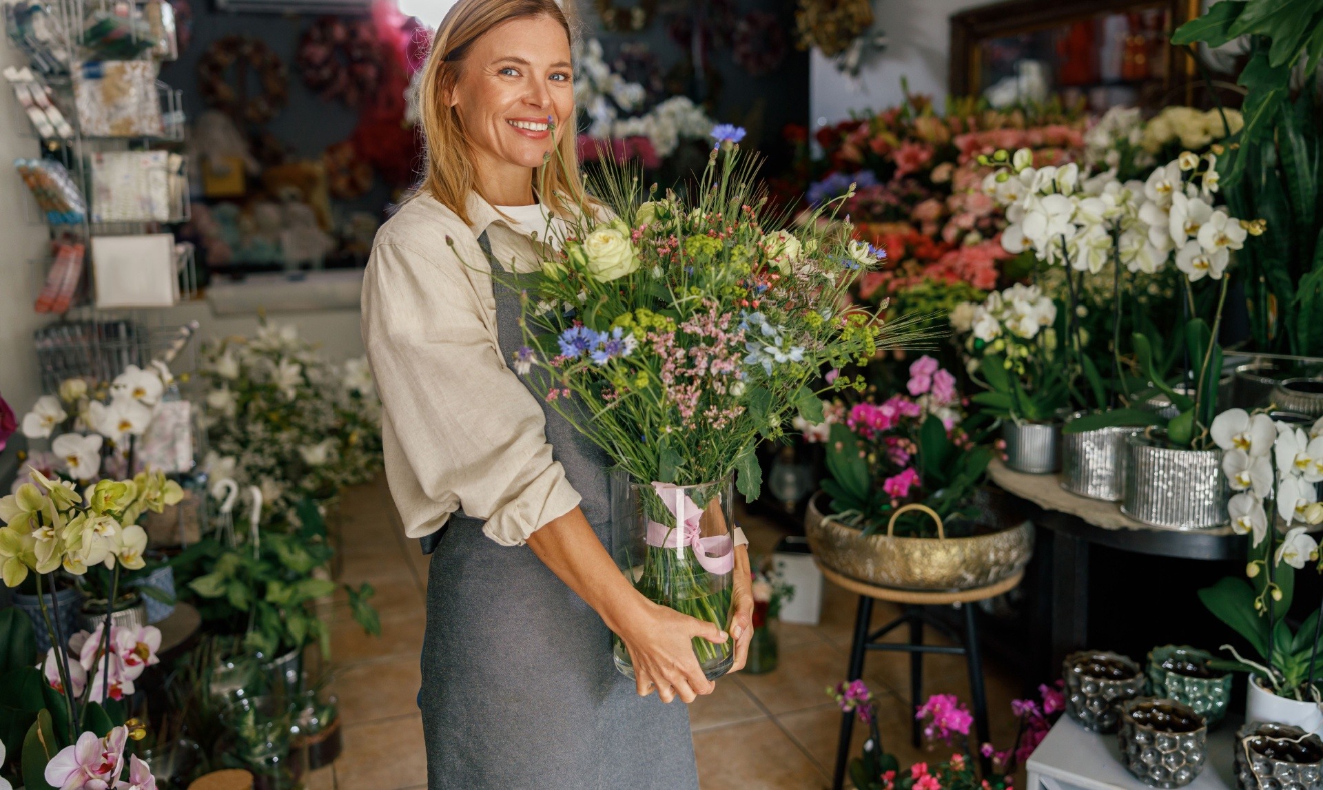 Woman standing with a plant. She is a florist 