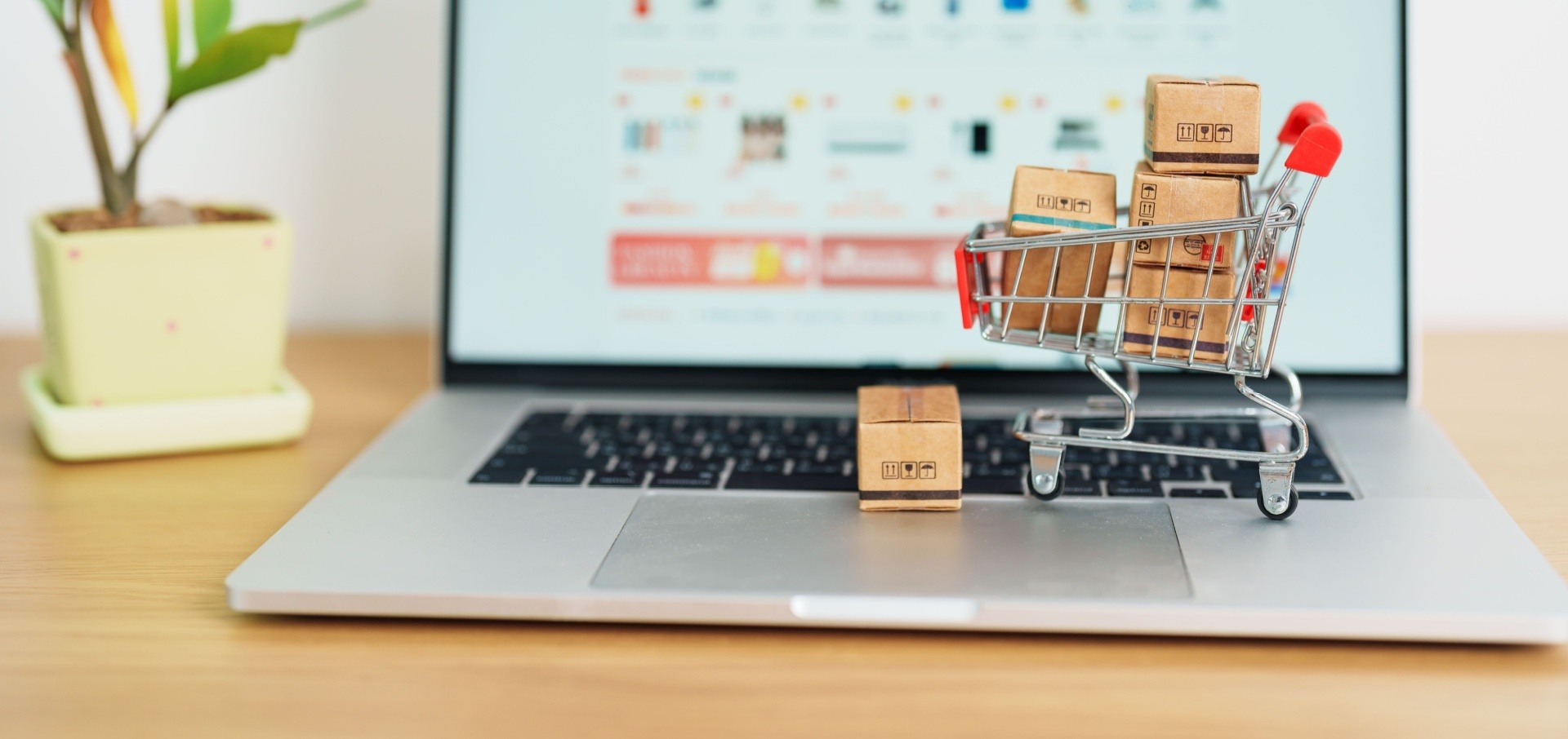 Selling digital products online with a small shopping cart on top of a laptop 