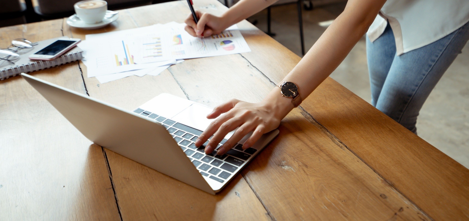 Woman writing and using the laptop