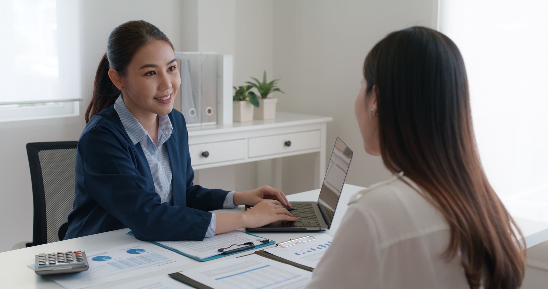 two women talking face to face in an interview style. 