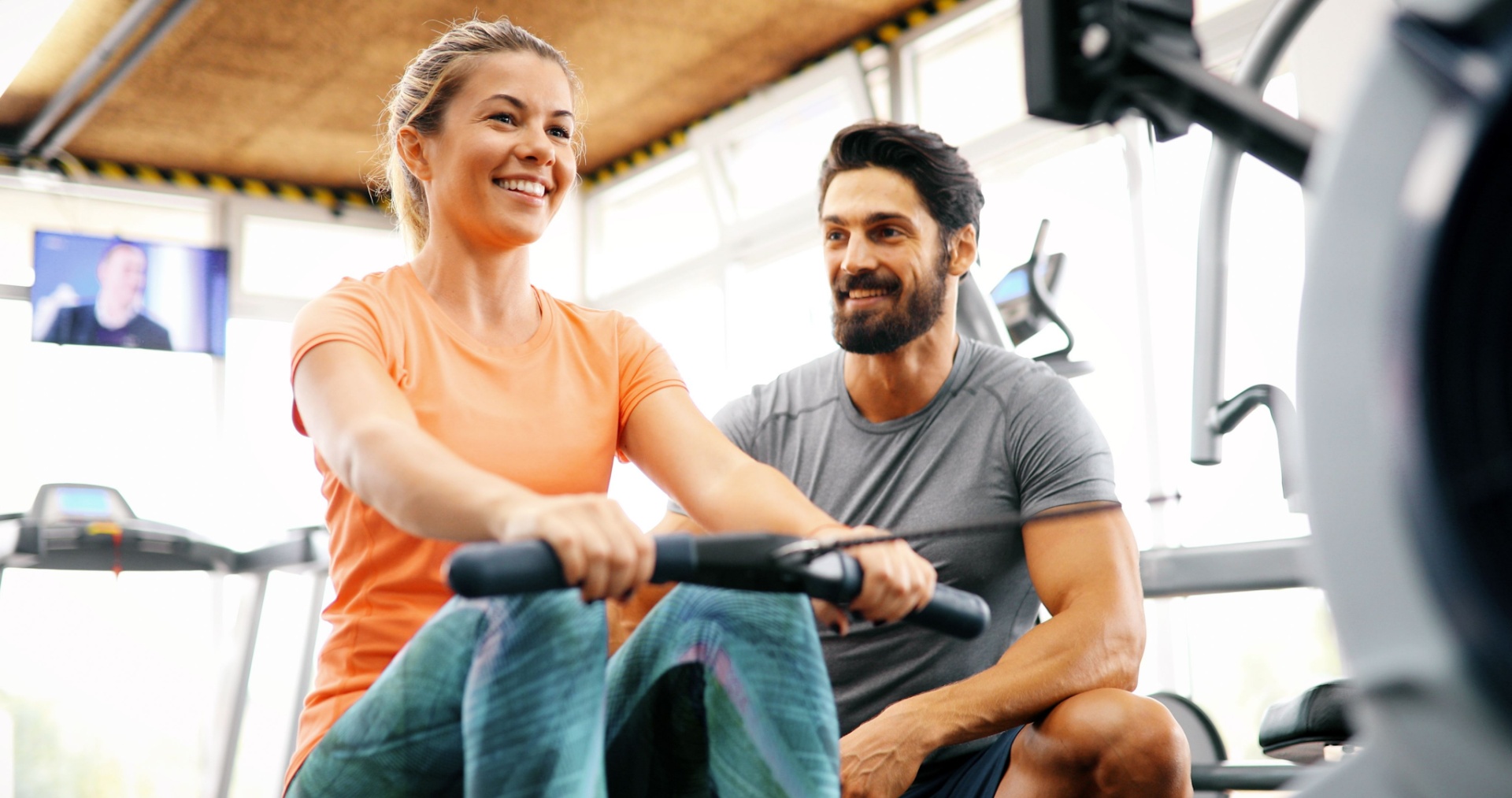 Man being a personal trainer for woman doing rows