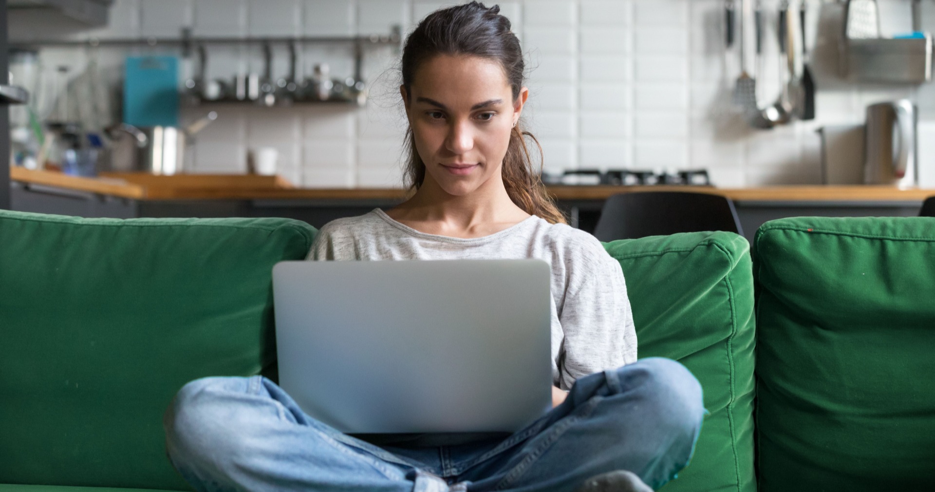 Woman learning matched betting on her laptop on the sofa 