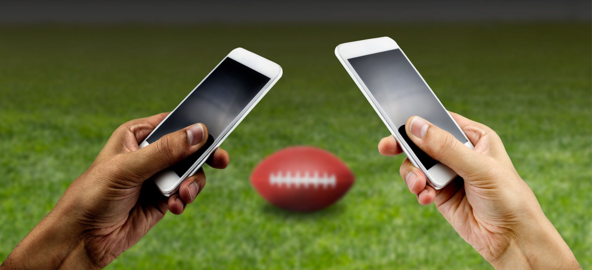 Two people holding iphones on an American football pitch