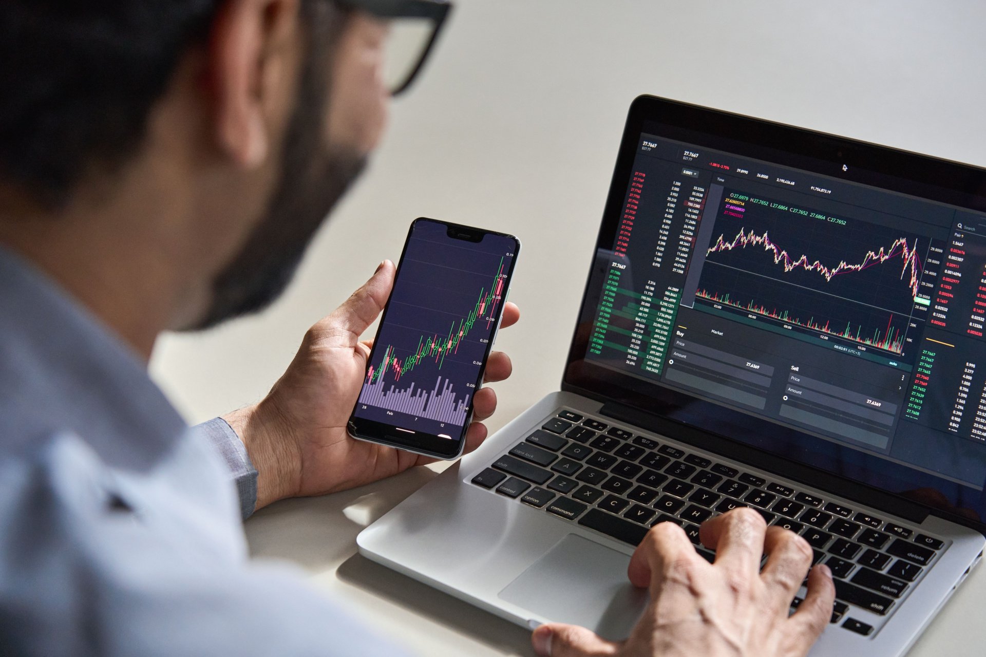 Man staring at stock market performance on iphone 