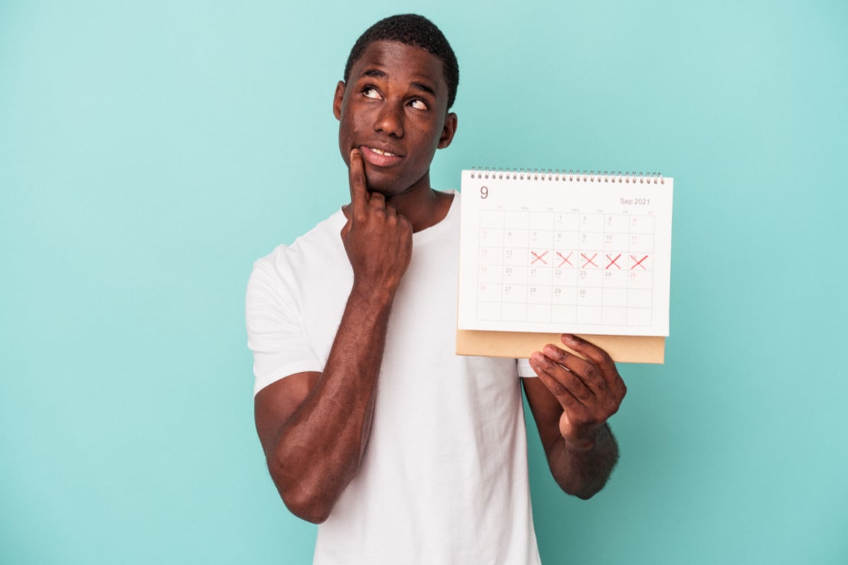Man holding a calendar with curious expression