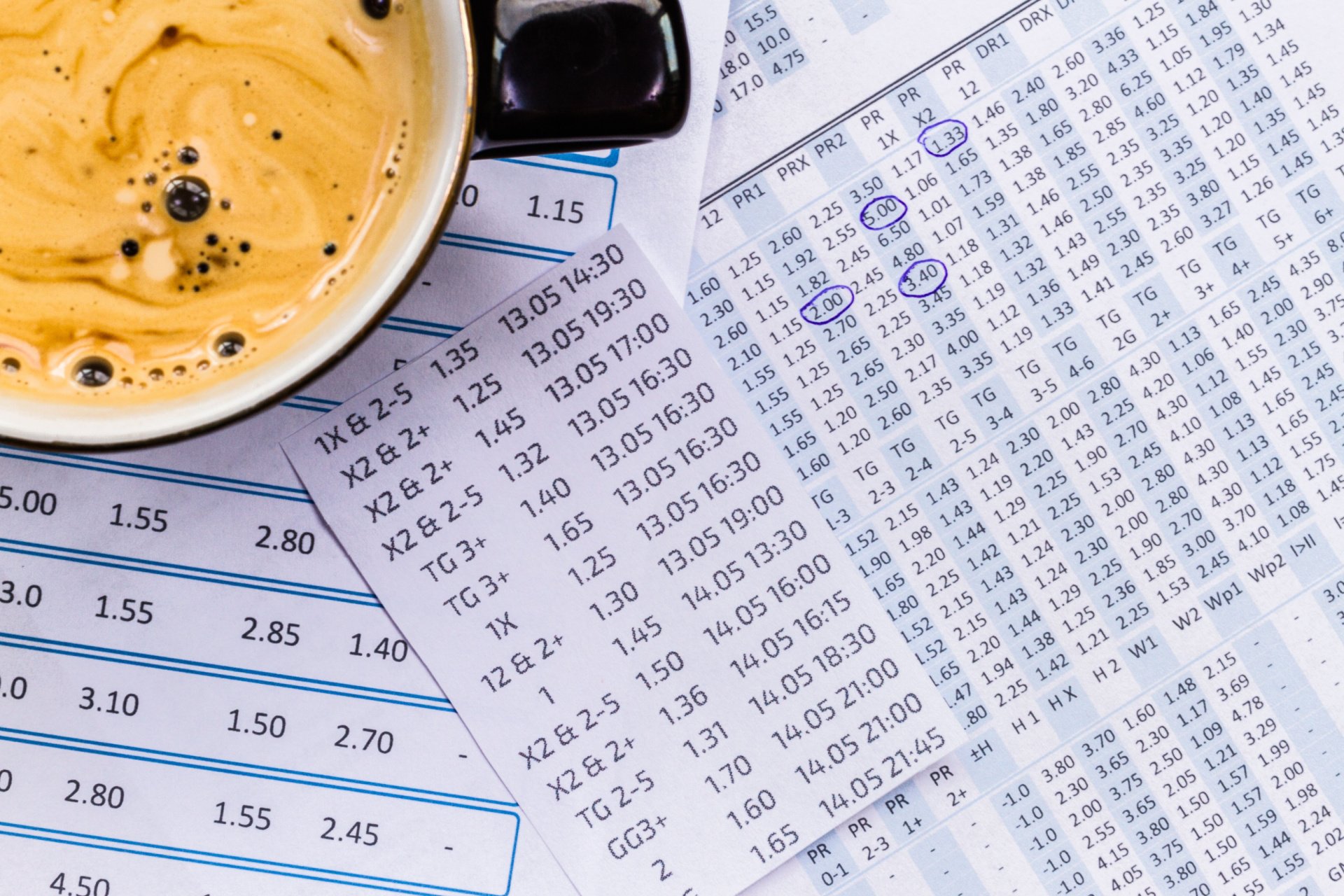 Betting odds sheets next to a cup of coffee