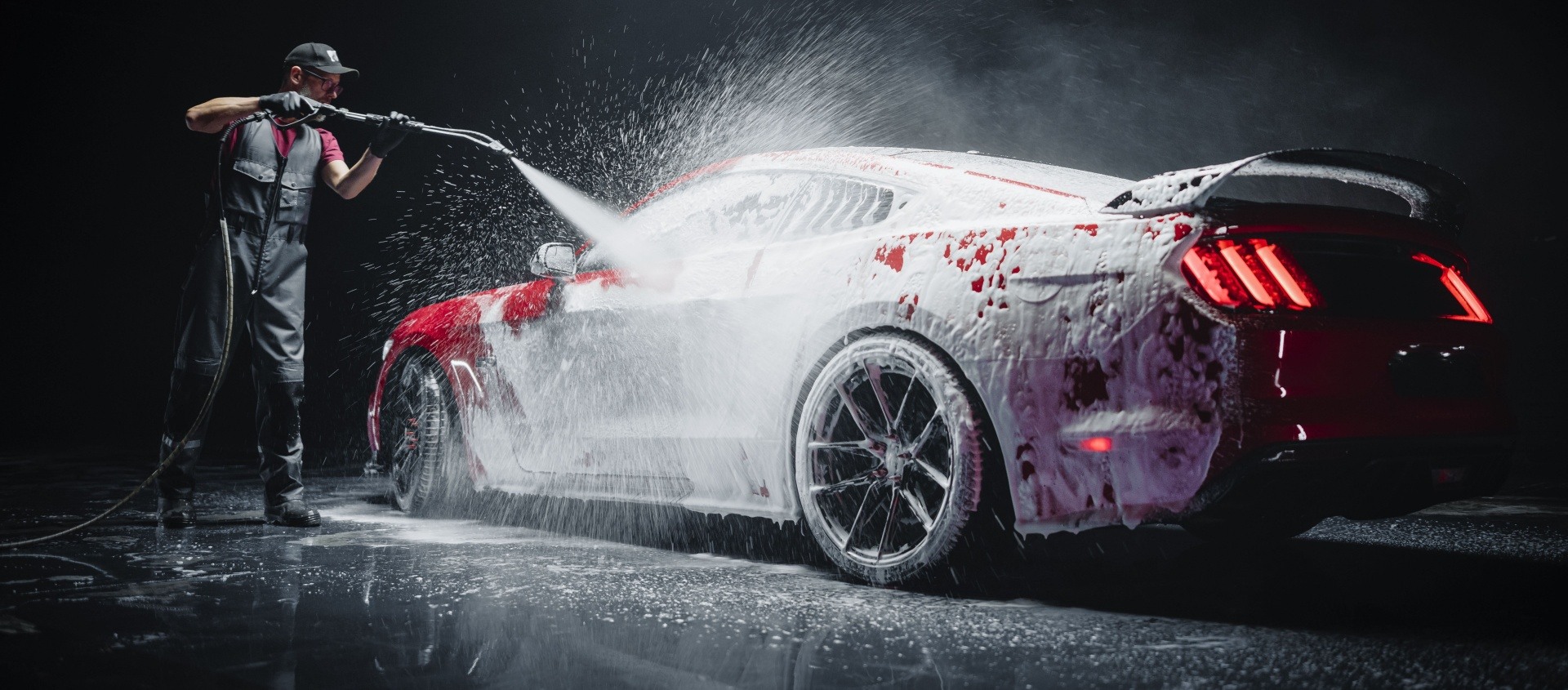 Man washing red sports car 