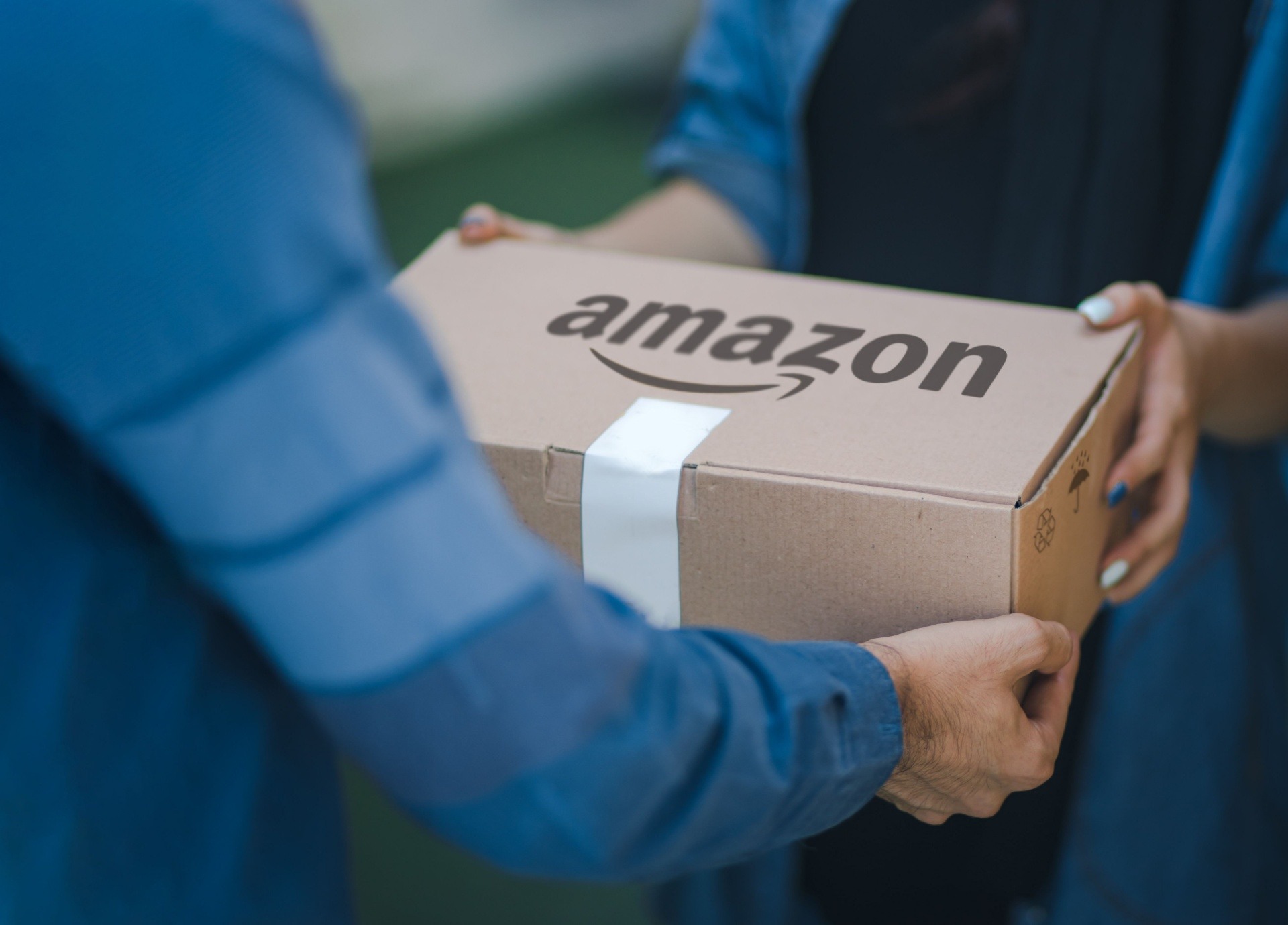man handing over a box with amazon written on it 