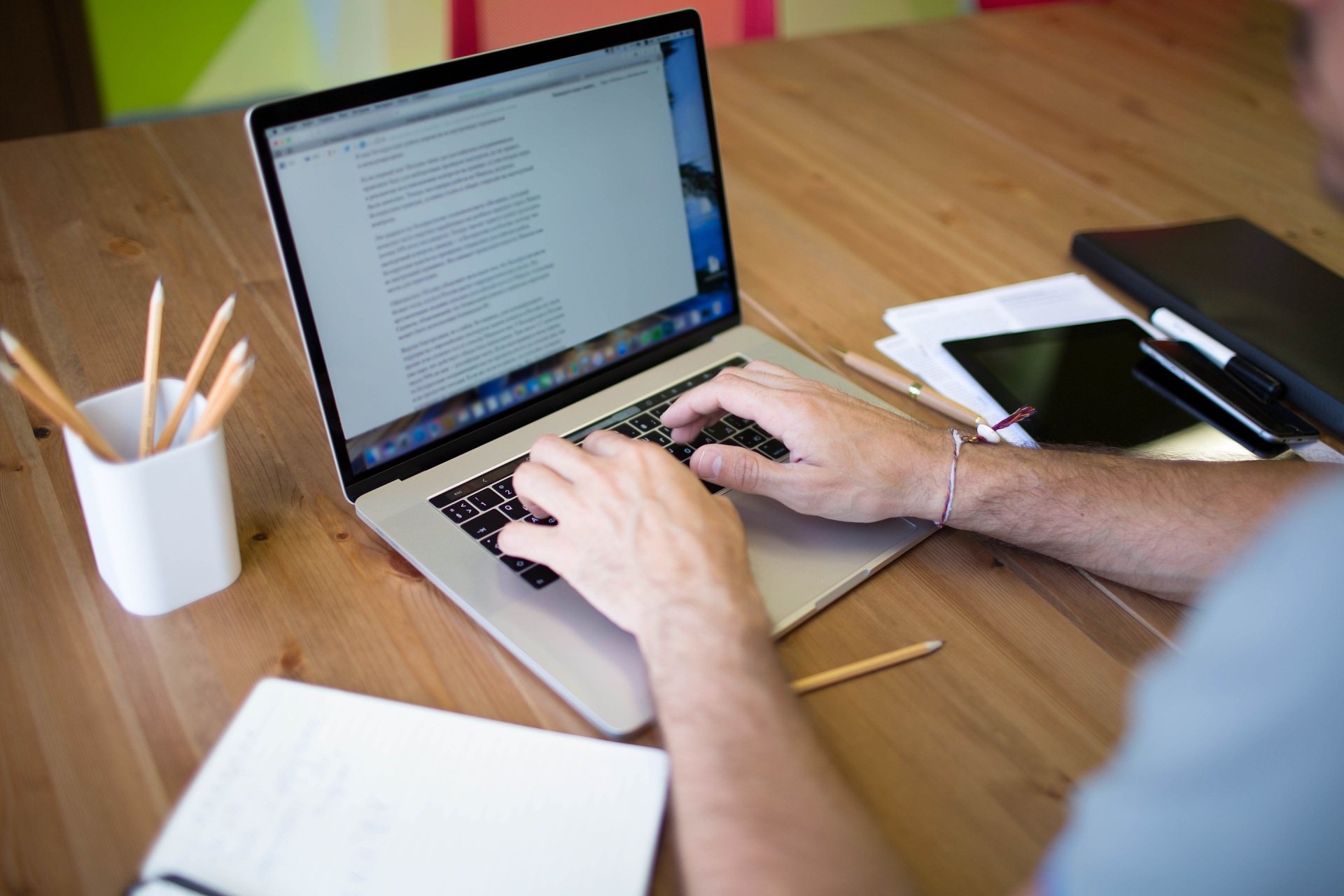 Man on a laptop typing sitting down at a desk