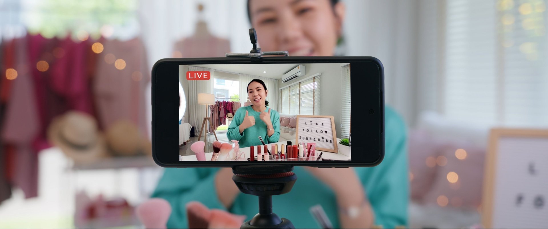 Phone live streaming a woman in a greeny blue top